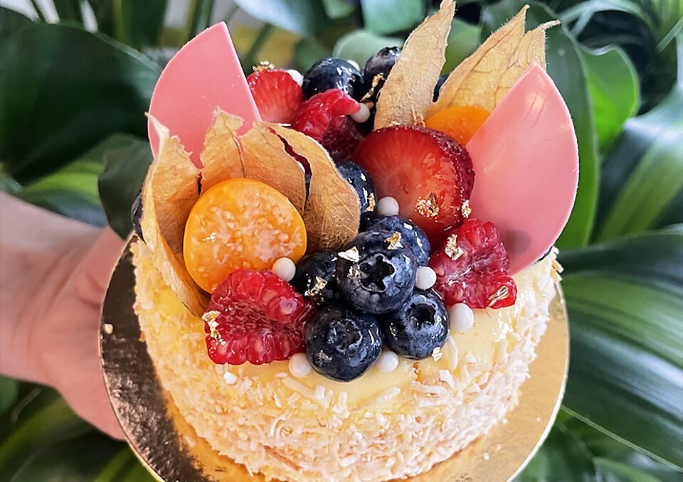 A GoodSide cake topped with berries, physalis and chocolate